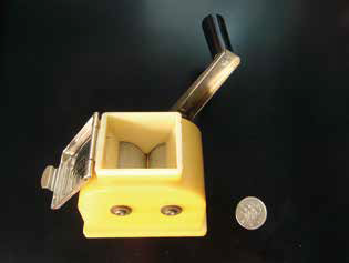 左：米の水分測定のために使われていたマイクロ籾摺り機（1967年ごろ）右：1964 年東京オリンピック記念 100 円硬貨（当時はまだ百円紙幣が流通していた）